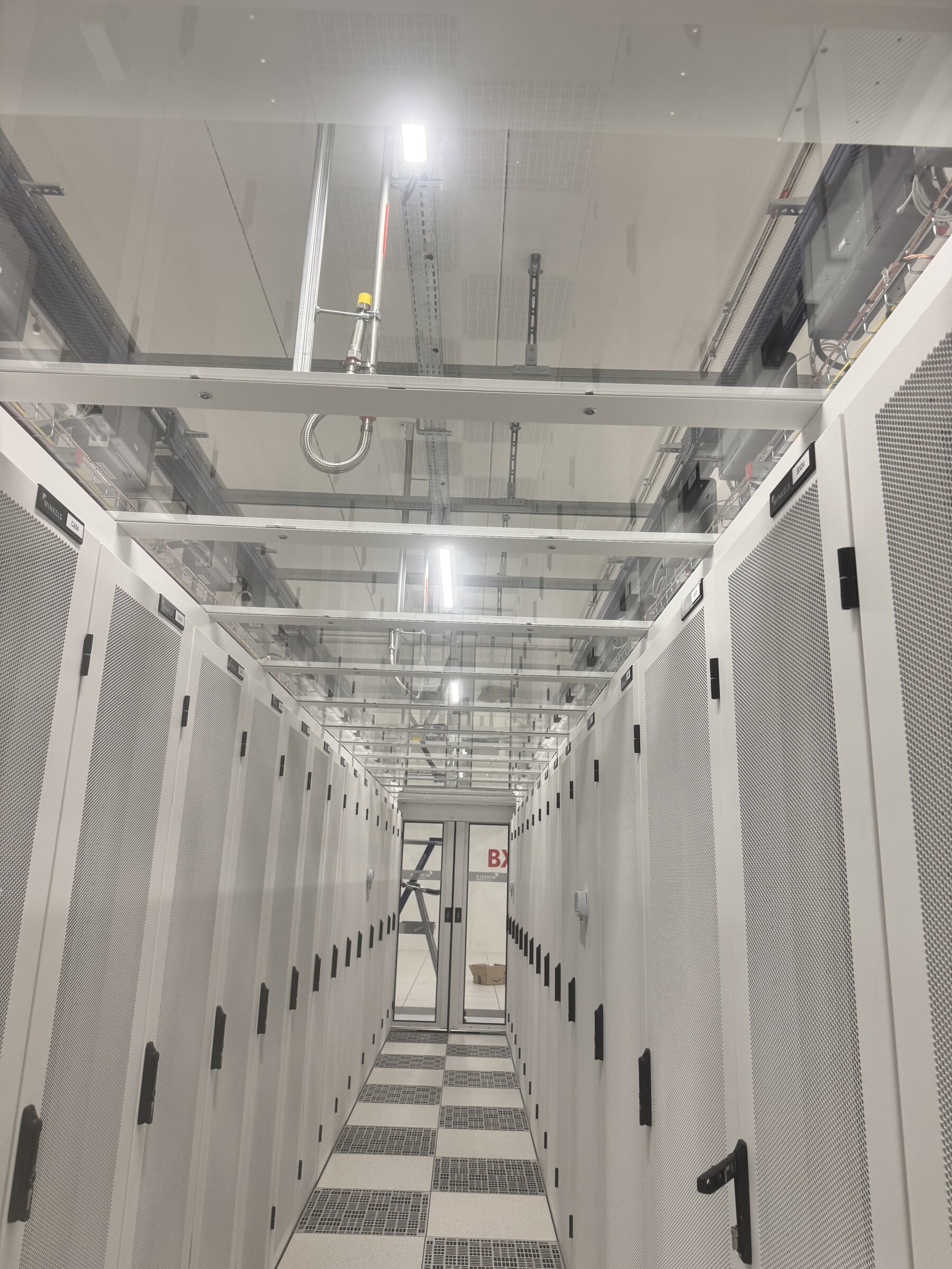 Data center — allée froide entre baies serveurs