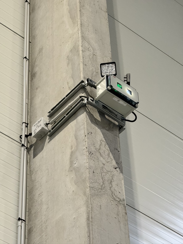 Projecteur LED industriel sur poteau béton — éclairage d'entrepôt